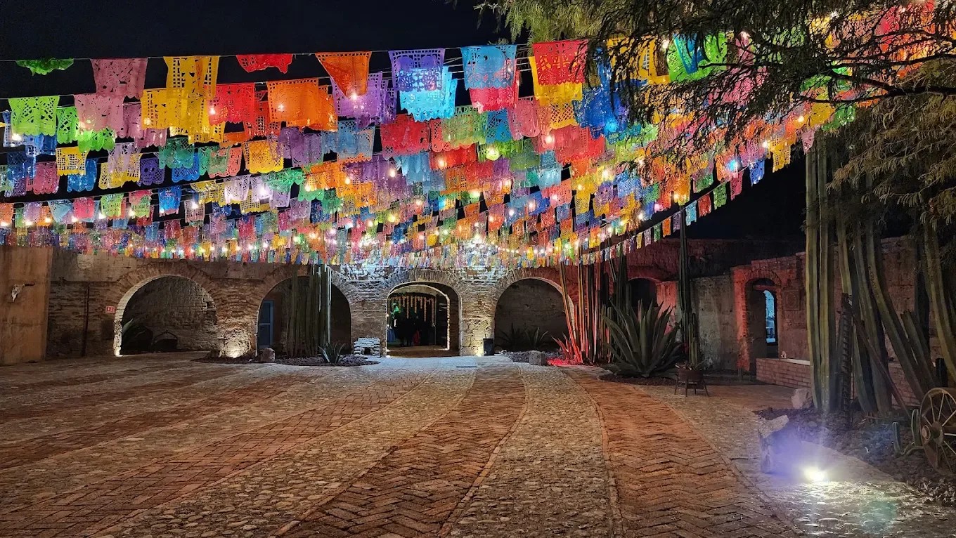 Colorful papel picado over a historic courtyard