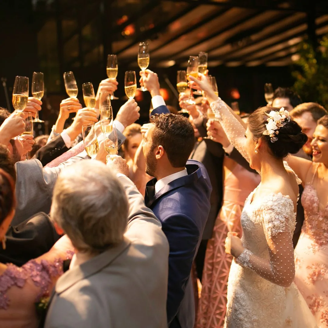 Wedding guests raising champagne glasses in celebration